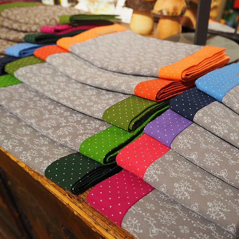 graue loopschals mit farbigen stoffvarianten zusammengelegt dargestellt